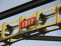 902846 Afbeelding van het smeedijzeren datumbordje '1912' op een overspanning van de Jeremiebrug over de Kruisvaart te ...